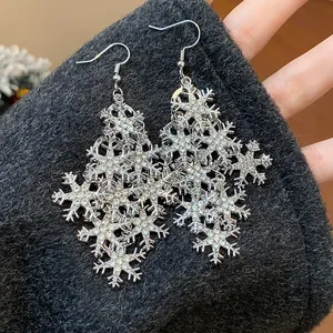 Gros plan détaillé de boucles d'oreilles pendantes flocons de neige avec strass.