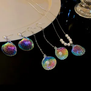 Vista detallada de pendientes y collar de concha de sirena con perlas decorativas