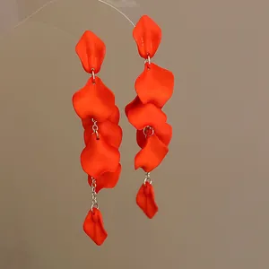 Detailed view of vibrant orange Bohemian petal tassel earrings with matte texture