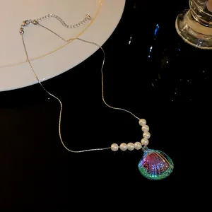 Primer plano de collar de concha iridiscente con perlas elegantes sobre fondo negro