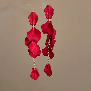 Detailed macro view of Bohemian style red rose petal tassel dangling earrings with chains