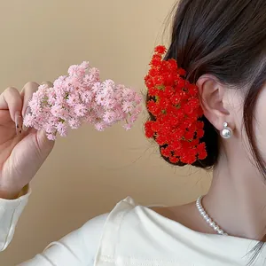 Dettaglio ravvicinato di fermagli per capelli con fiori in acrilico rosa e rossi