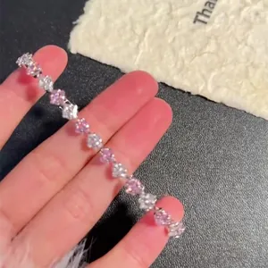 Dettaglio di un bracciale in zircone a taglio quadrato con pietre rosa e bianche.