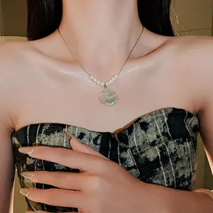 Primer plano de un collar de perlas de concha de sirena con acabado iridiscente en una modelo