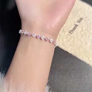 Primo piano di un elegante braccialetto di zirconi rosa e bianchi al polso