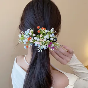 Dettaglio di una molletta per capelli a fiori in acrilico su un'acconciatura media