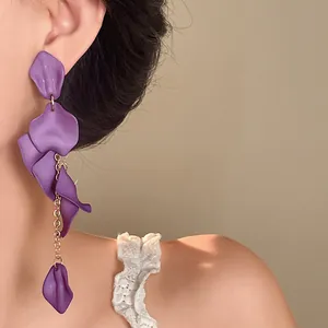 Detailed view of stylish purple bohemian petal tassel earrings on a model's ear