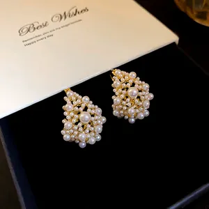 Close-up detail of elegant clustered pearl earrings on a premium black velvet jewelry box