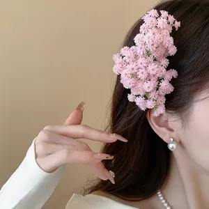 Dettaglio di un fermaglio per capelli a fiori rosa con eleganti gioielli di perle