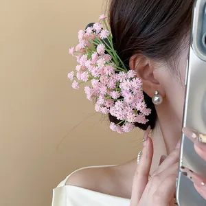 Vista laterale dettagliata di un delicato fermaglio per capelli con fiori rosa indossato da modella