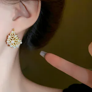 Detailed close-up showing elegant French style pearl cluster earrings worn on model ear