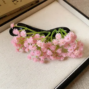 Dettaglio di un fermaglio per capelli in acrilico con cluster di fiori di gipsofila