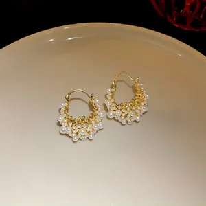 Detailed view of French luxury gold-plated hoop earrings with elegant white pearls