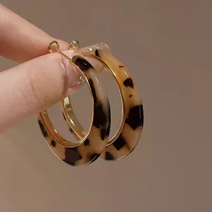 Detailed macro shot of vintage tortoiseshell leopard print C-shaped hoop earrings