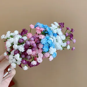Dettaglio di un fermaglio per capelli a grappolo di fiori in acrilico colorato e dolce