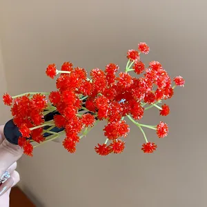 Primo piano dettagliato di un dolce fermacapelli in acrilico con fitti grappoli rossi.