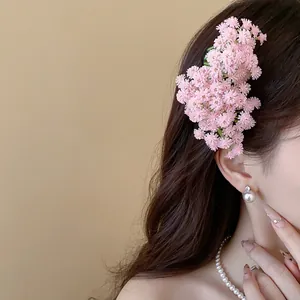 Dettaglio ravvicinato di un romantico fermaglio per capelli con fiori rosa in acrilico