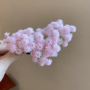Dettaglio ravvicinato di una dolce molletta per capelli con fiori rosa finti in mano