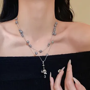 Elegant double-layer grey pearl necklace featuring a sparkling rhinestone Saturn pendant charm