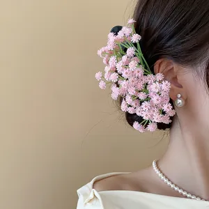 Vista dettagliata di un elegante fermaglio per capelli con fiori rosa in acrilico.