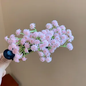 Dettaglio del fermaglio per capelli con grappolo di fiori in acrilico rosa e steli