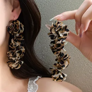 Detail shot of stylish handmade leopard print fabric flower drop earrings for women.