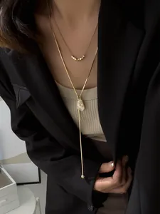 Detailed view showing the layered effect of gold-plated adjustable necklaces on a model.