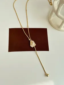 Detail of gold-plated adjustable lariat necklace with gold leaf geometric pendant