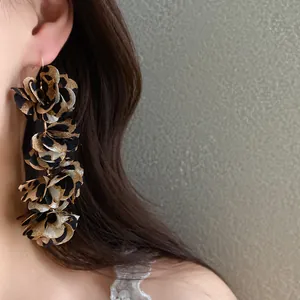 Detailed macro view of leopard print fabric flower drop earrings showing texture.