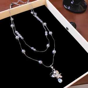 Double-layer grey pearl necklace with rhinestone Saturn pendant detail