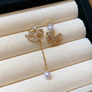 Elegant asymmetric gold plated rocking horse tassel earrings with zircon pavé and pearls