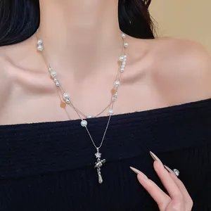 Close-up of double-layer necklace with pearls and rhinestone Saturn pendant on model