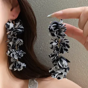 Close-up of elegant fabric leopard print flower drop earrings worn by a model