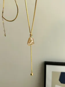 Detailed view of a gold-plated necklace with irregular geometric gold foil pendant
