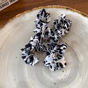 A detailed view showing the layered fabric petals on these leopard print flower earrings