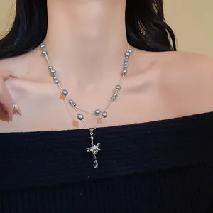 Detail of French retro double-layer necklace with gray pearls and Saturn pendant