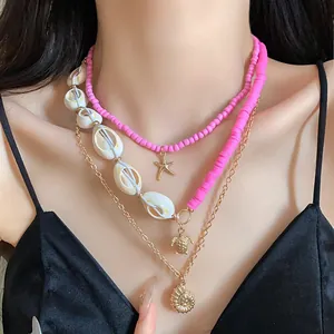 Close-up of pink layered beach necklace set with gold starfish and shell pendants
