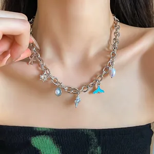 Close-up detail of an ocean themed charm necklace with shells and pearls worn on model