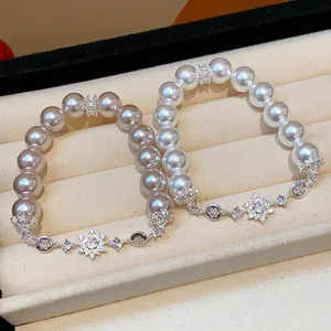 Close-up of elegant pearl bracelets with sparkling snowflake charms in a jewelry box
