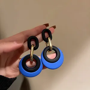 Detailed view of stylish blue and black geometric link earrings with golden accents