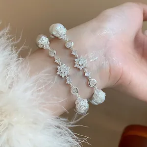Close-up of elegant French style pearl bracelet with shimmering zirconia flower detail