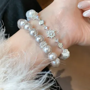Detailed macro view of elegant French style zircon flower and pearl bracelet set on wrist