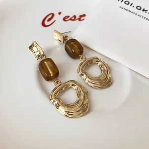 Macro detail of Maillard style brown resin bead earrings with vintage hammered gold finish