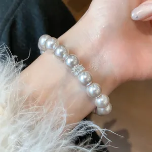 Close-up detail of a French style pearl bracelet with a zircon spacer on a female wrist
