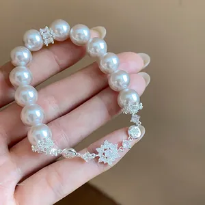 Exquisite close-up of an elegant pearl bracelet featuring sparkling zircon flower charms.