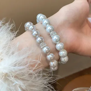 Close-up detail of elegant French style white pearl bracelets with zircon accents on wrist