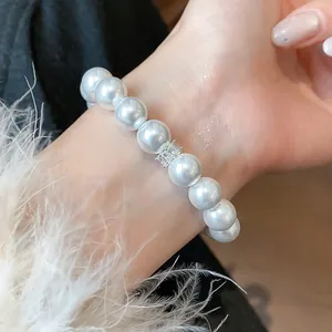 Detail view of elegant French style pearl bracelet with zircon accent on wrist