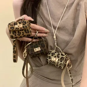 Close-up of stylish leopard print micro bag charms with gold hardware in three different colors.