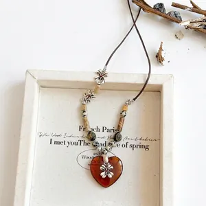 Ethnic style beaded necklace with amber heart and silver floral metal accents