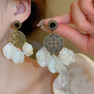 Elegantes pendientes dorados de estilo chino con mandalas y gotas de pétalos blancos